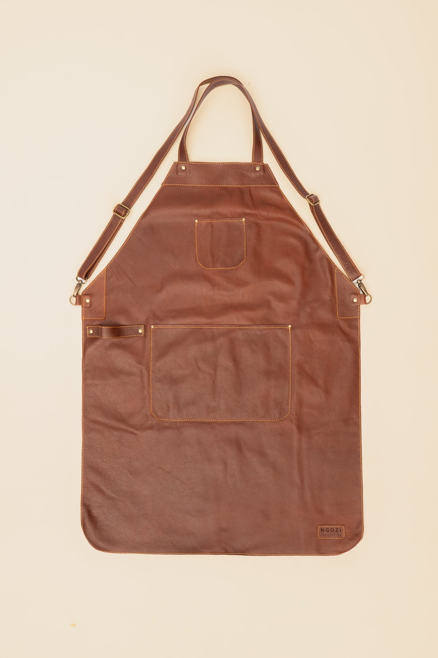 Ngozi Collection chocolate leather apron with cross-back straps and front pockets