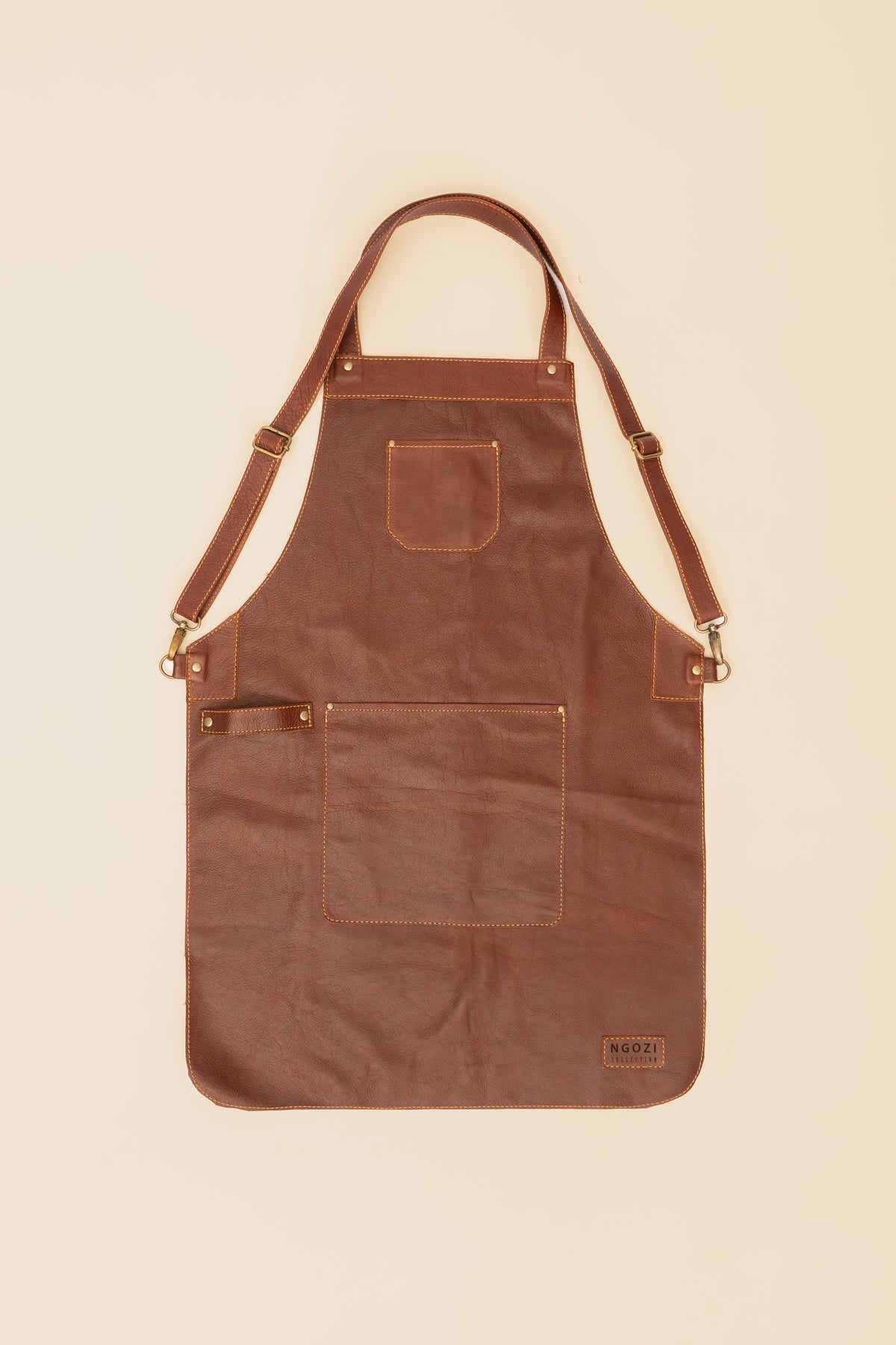 Ngozi Collection chocolate leather apron showing antique brass fittings