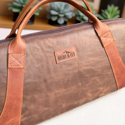 Ngozi Collection chocolate leather rifle bag showing top handles and brand label