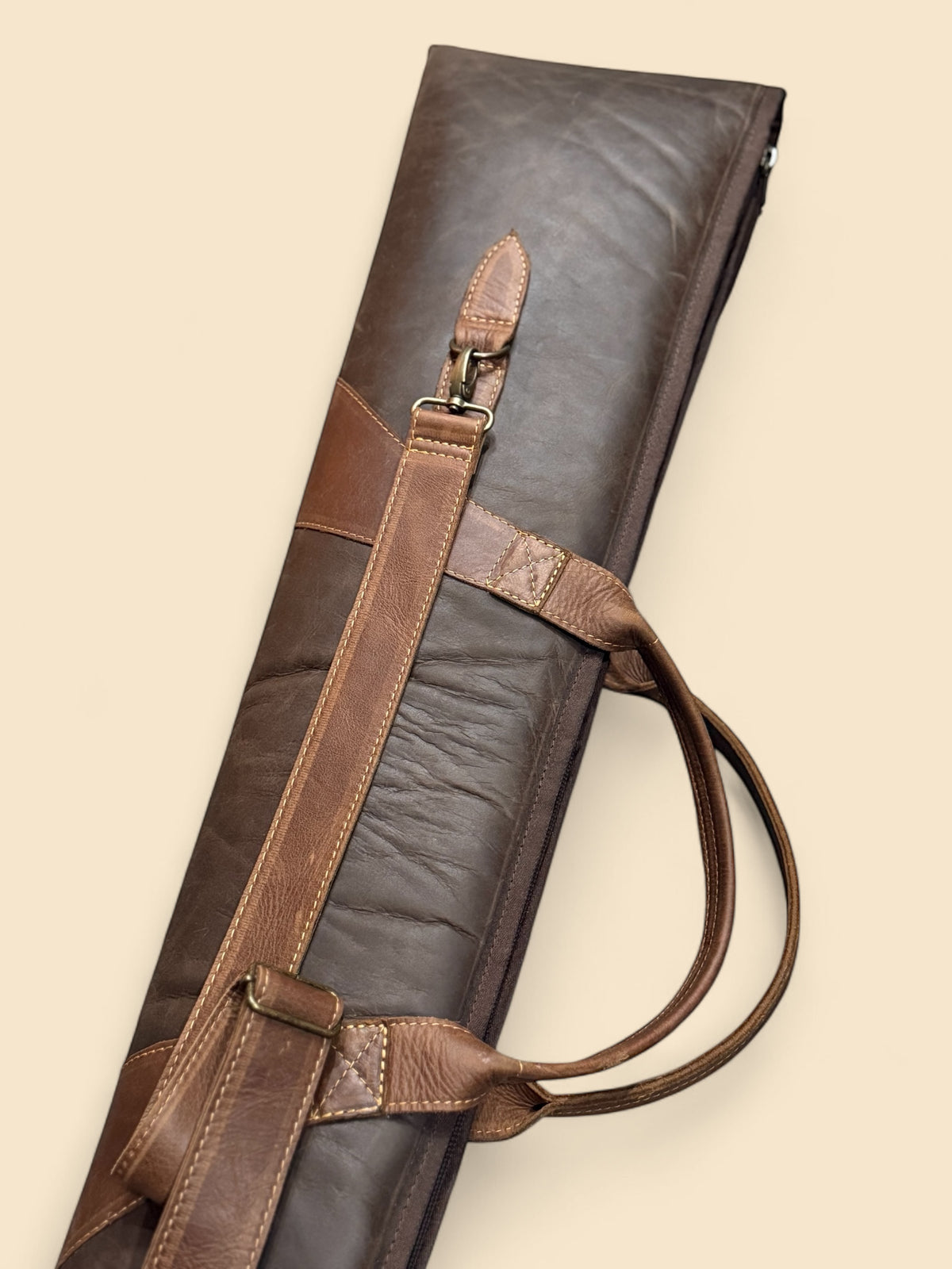 Ngozi Collection chocolate leather shotgun sleeve shown upright with detachable strap