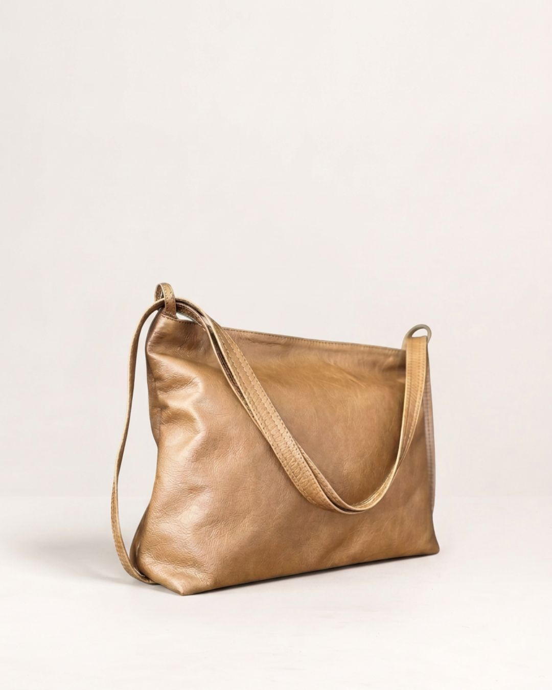 Ngozi Collection tan leather slouch bag with adjustable strap, side view